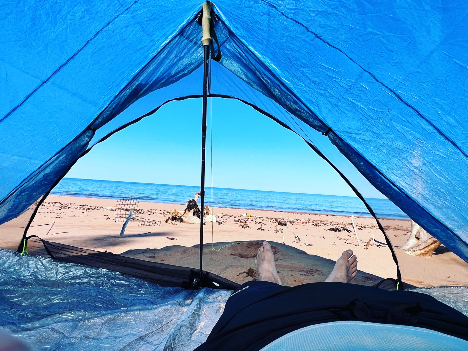 View from inside a blue tent looking out at the ocean